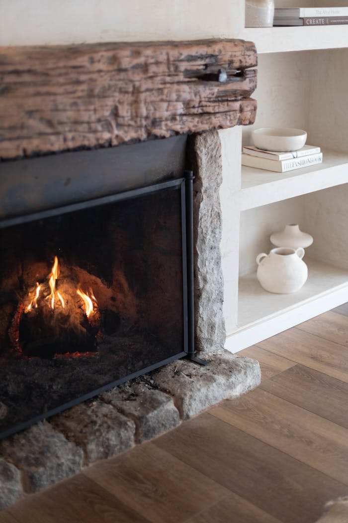 about-01 Warm and inviting fireplace with wooden mantel in a stylish living room setting, featuring modern decor.