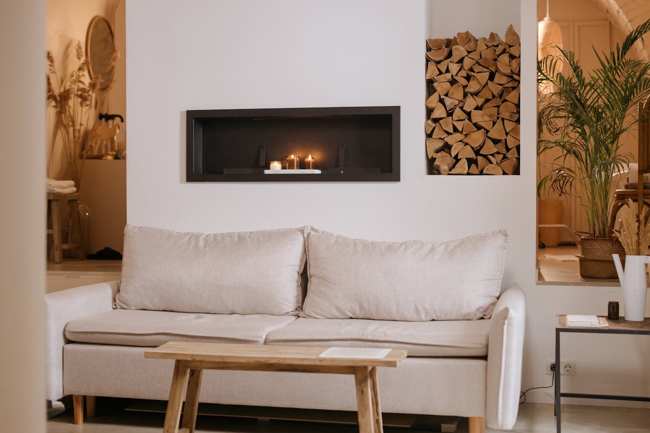impact-img A serene minimalist living room featuring a clean lined sofa, wooden accents, and ambient candles.